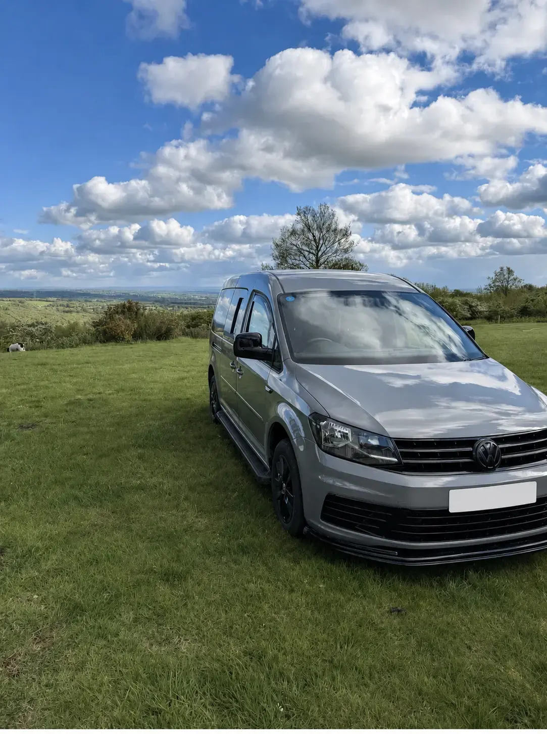 Sold grey Volkswagen camper in a countryside setting with its registration concealed for privacy